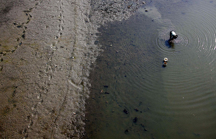24 hours in pictures: A farmer washes himself in the drough-effected Neijing River 