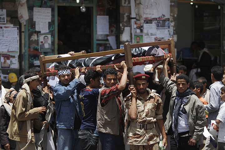 Yemen: Anti-government protesters carry the body of a fighter in Sana'a