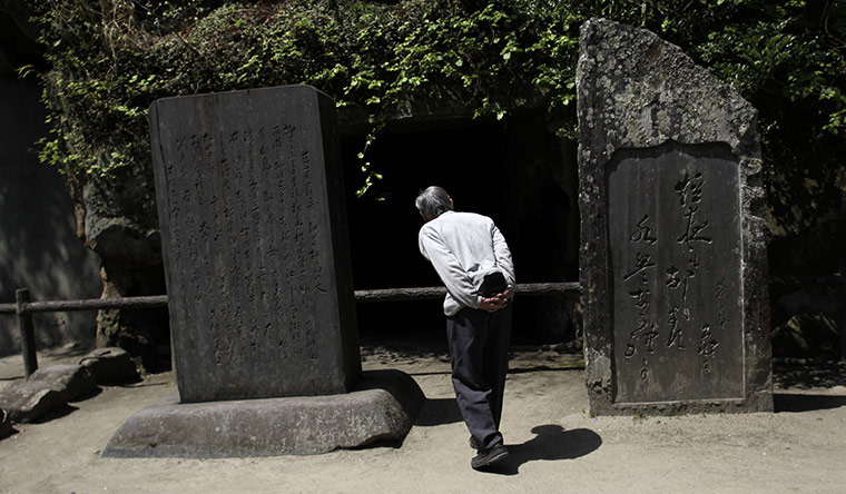 24 hours in pictures:  A man reads a scripts carved on stones at Zuiganji temple in Matsushima