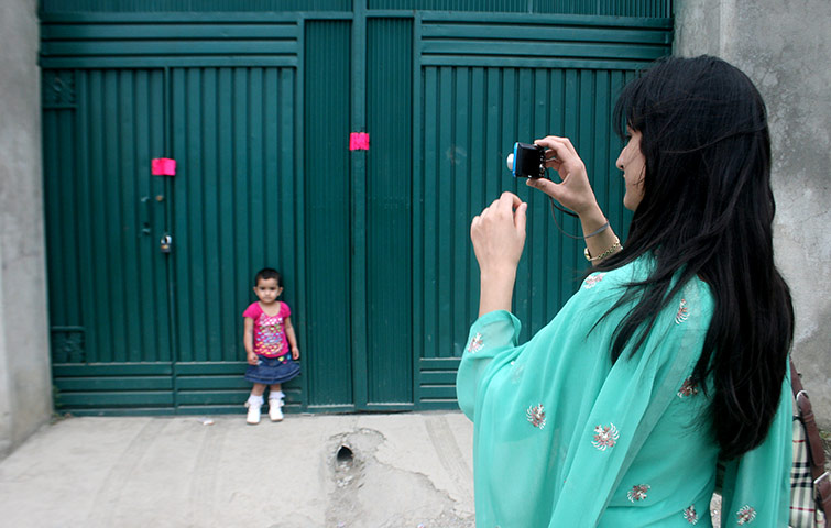 24 hours in pictures: A woman photographs her daughter in Abbottabad, Pakistan