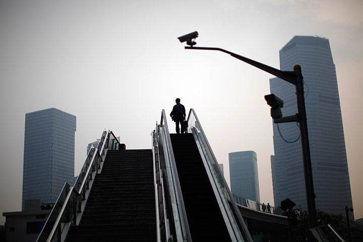 24 hours in pictures: A man stands on an escalator at the financial district, Shanghai
