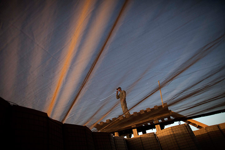 24 hours in pictures: US Army officer stands on an overlook in Helmand Province