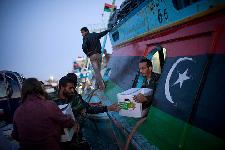 24 hours in pictures: Libyan rebels upload goods into a fishing ship before leaving Benghazi