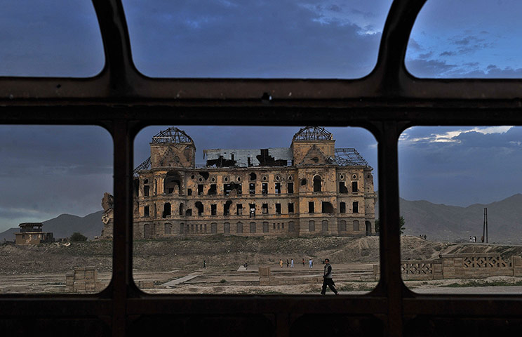 24 hours in pictures: n Afghan man walks past the ruins of Darul Aman palace