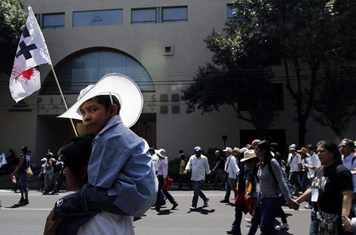 24 hours in pictures: Mexico City, Mexico: A woman carries her son during a march