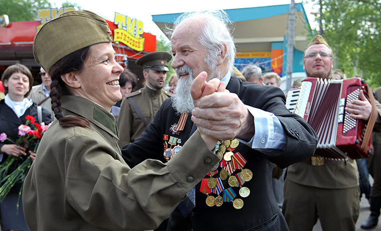 moscow vicotory day  : A WW II veteran dances with a woman wearing a Soviet era military uniform