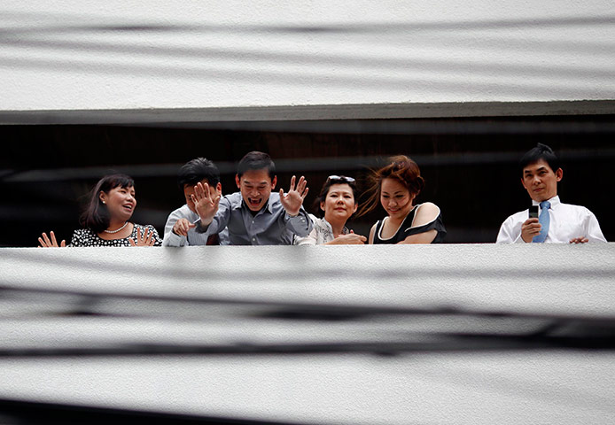 24 hours in pictures: People react from the parking lot of a business building, Bangkok