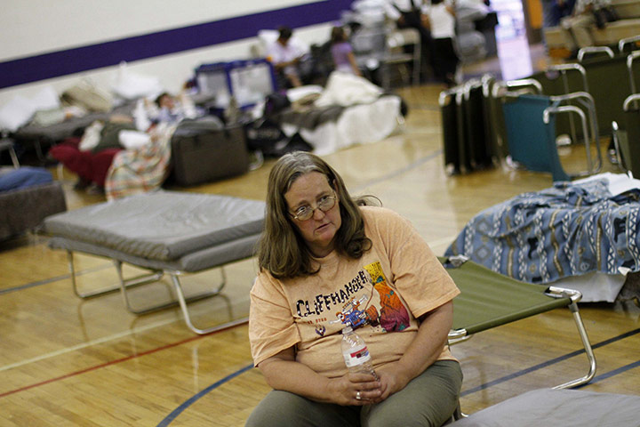 Arizona Wildfire: A woman sits on a cot at Blue Ridge High School