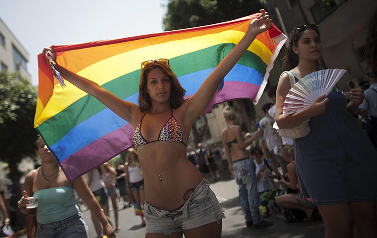 Gay Pride in Tel Aviv: A young women waves a rainbow flag