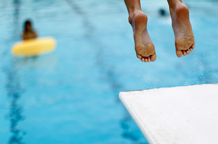 24 hours in pics: A boy jumps off a diving board into a swimming pool