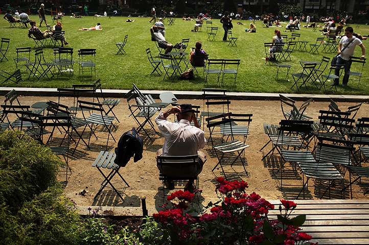 24 hours in pics: A man takes a break at Bryant Park during a heat wave, New York