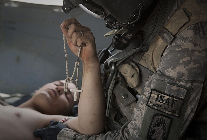 24 hours: Sangin, Afghanistan: A wounded soldier holds rosary beads