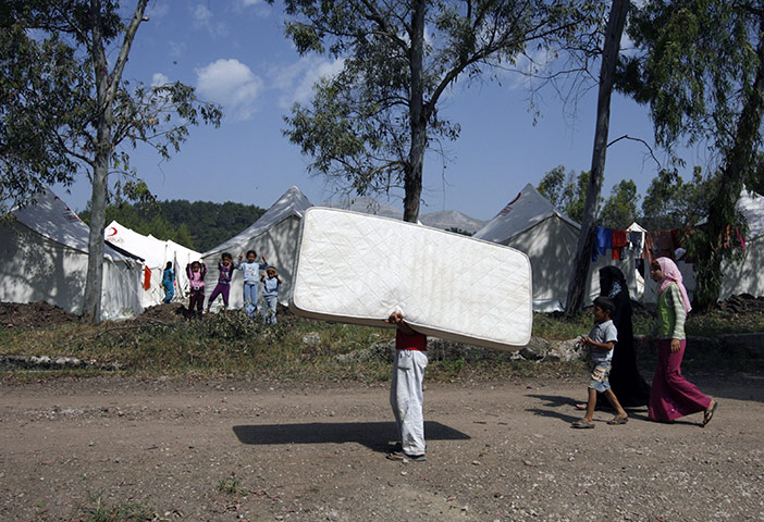 Syrian refugees: Syrian refugees move their belongings inside a camp in Yayladagi