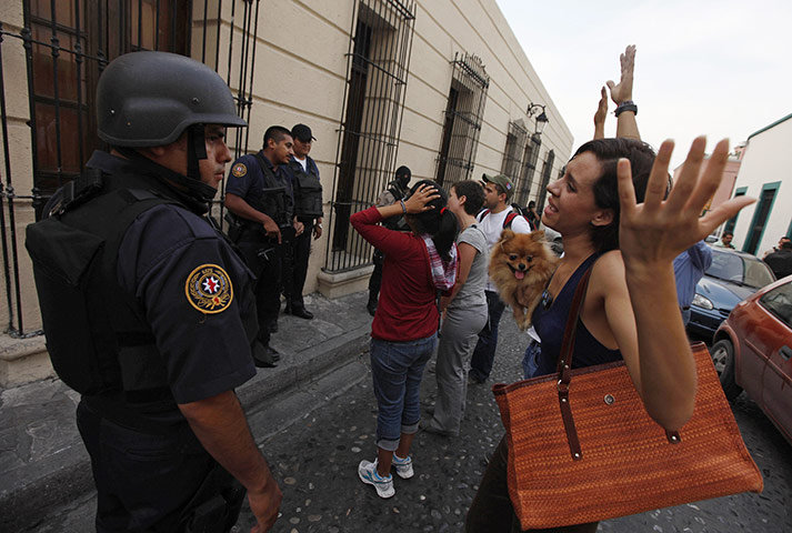 FTA: Tomas Bravo: A woman argues with a policeman during a candlelight vigil 