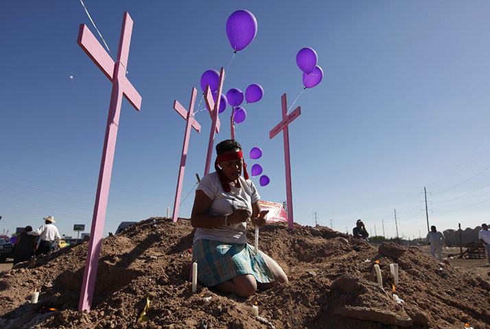 FTA: Tomas Bravo: A woman prays next to pink crosses erected in memory of women murdered 