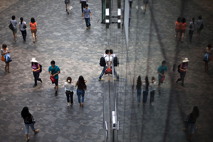 24 hours in pictures: Customers are reflected in the windows of a shopping mall in Beijing