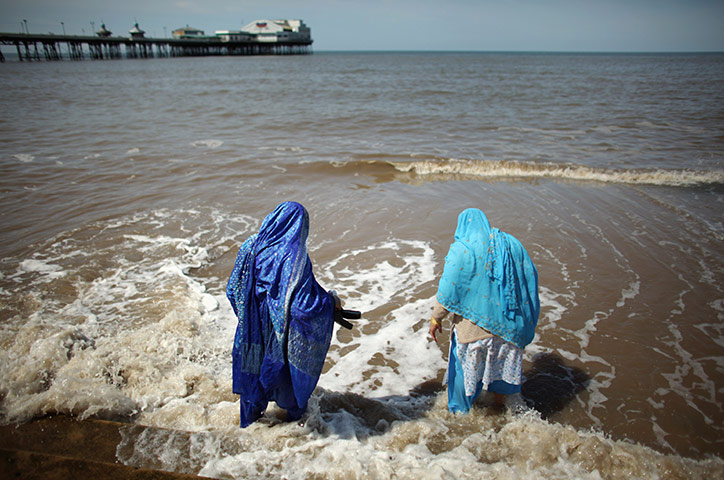 24 hours in pictures: Blackpool, England: Two Asian women paddle in the sea