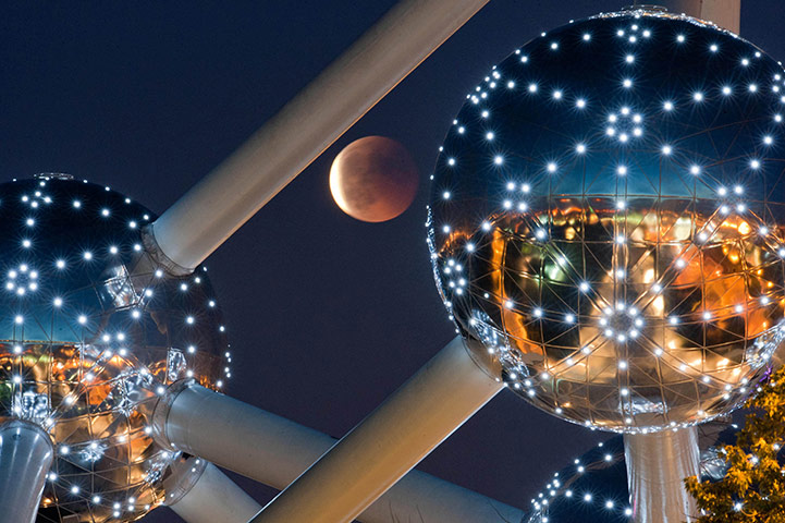 solar eclipse and lunar eclipse. The lunar eclipse is seen over the Atomium in Brussels Photograph: Geert