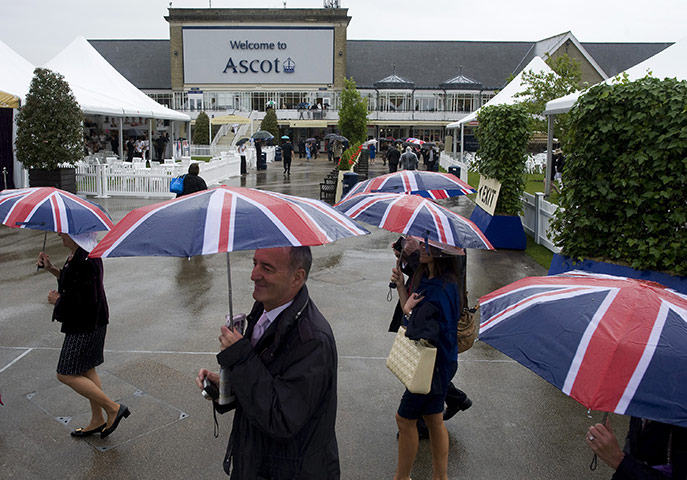 Ascot Ladies Day: Race goers shelter under umbrellas
