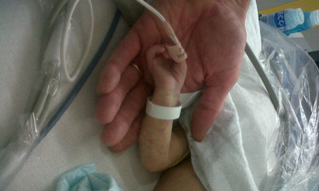 A baby holds a doctor's hand at Great Ormond Street Hospital on 16 June 2011. Photograph: Rowenna Davis for the Guardian