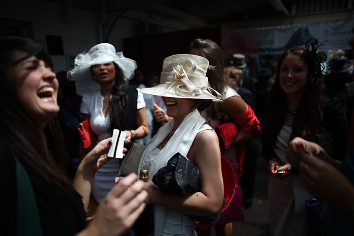 Ascot Ladies Day: Race goers laugh as they arrive by train at Ascot