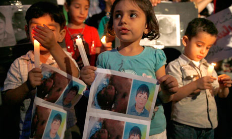 Syrian children carry pictures of Hamza al-Khatib