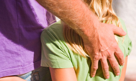 Eight years old girl with hand in back pocket of her father who has arm protectively about her