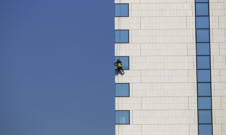 24 hours in pictures: A worker cleans the windows of a hotel building in downtown Sofia