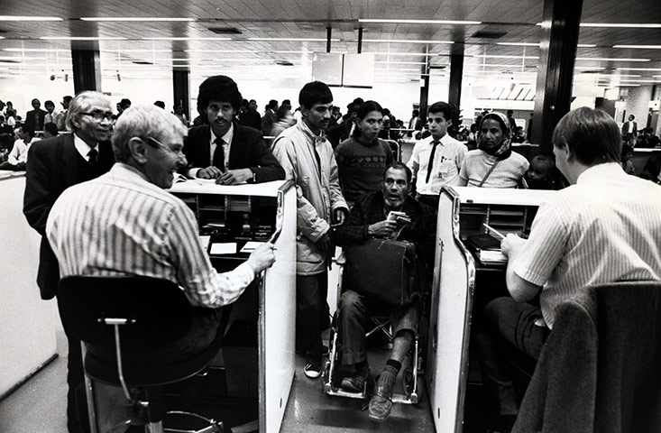 E Hamilton West: A Uganda Asian family with ummigration officials at Heathrow Airport