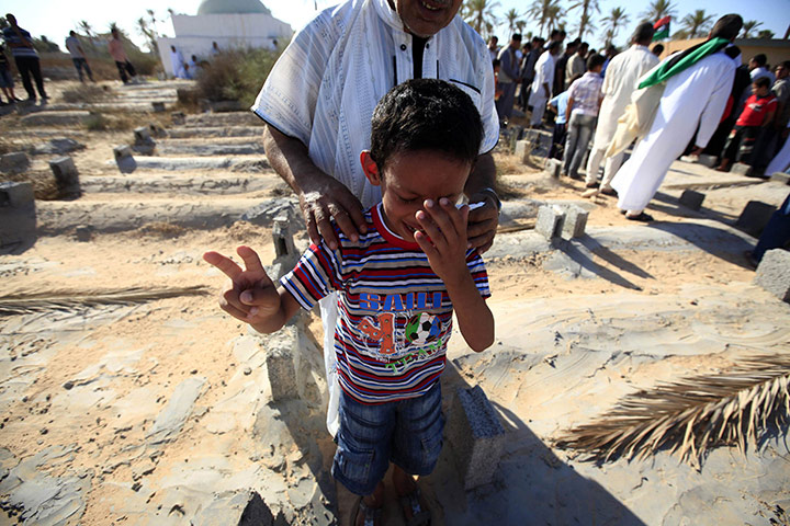 24 hours: Misrata, Libya: A boy flashes a victory sign as he mourns for his relative