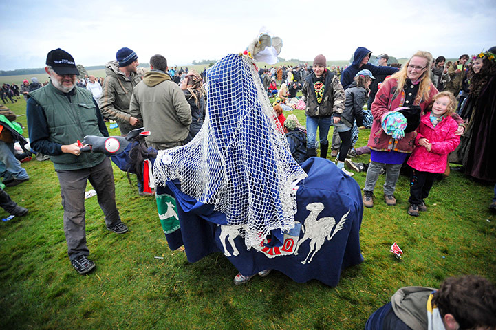 Summer solstice: A man in a horse costume entertains revellers as they watch the sunrise 
