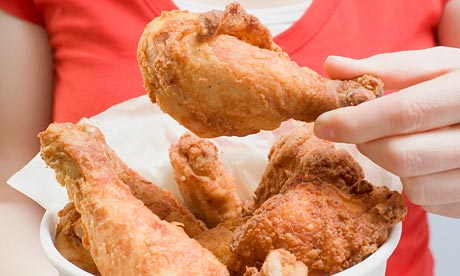 Woman holding deep-fried chicken drumsticks