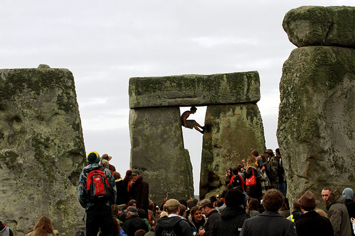 Summer solstice: A reveller climbs on one of the stones 
