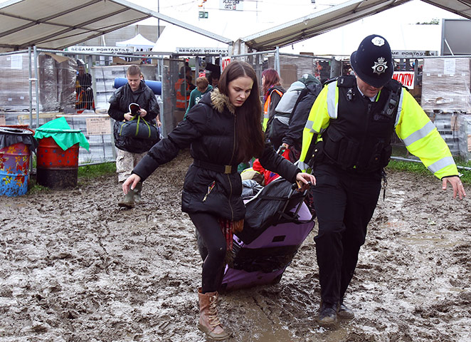 Glasontbury arrivals: A police officer helps a festival goer with her camping gear