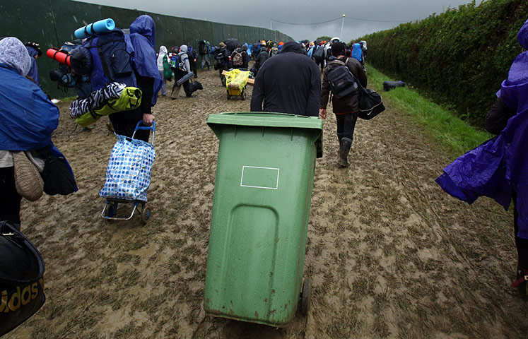 Glasontbury arrivals: A man drags a wheelie bin as he arrives at the Glastonbury Festival site 