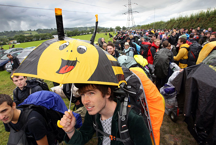 Glastonbury arrivals: Festival-goers queue in the car park while they wait to gain access 