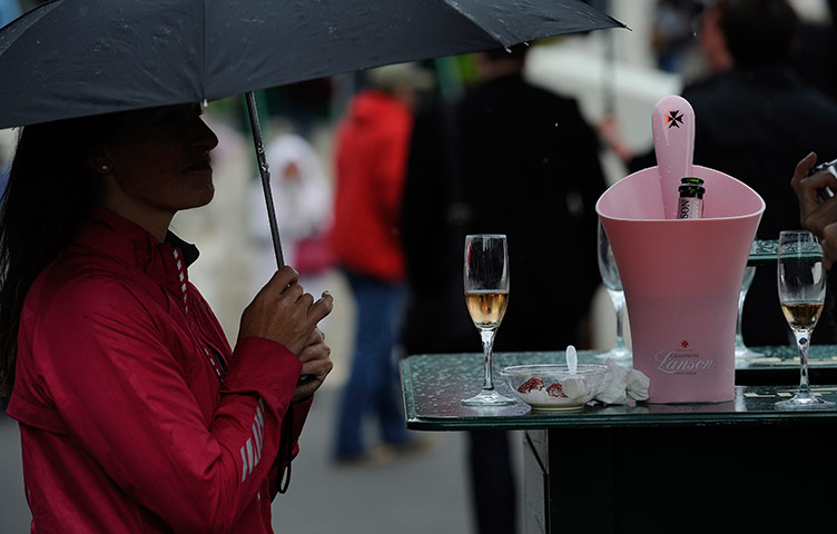 Wimbledon day 3: Spectator has a drink during a rain break at Wimbledon