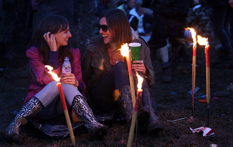 Glastonbury day 1: Festival goers share a joke as they sit at the Stone Circle 