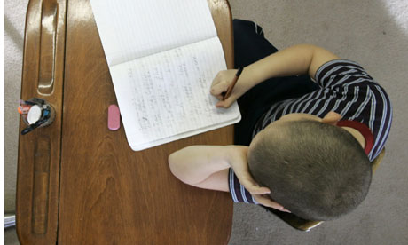 Schoolboy writing in text book