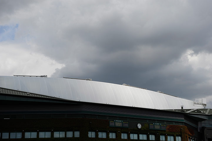 Wimbledon day 4: The sun shines on the closed roof of centre court as dark clouds gather.