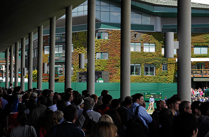 Wimbledon day 4: Spectators watch the action on court 4 from  under the new court 3