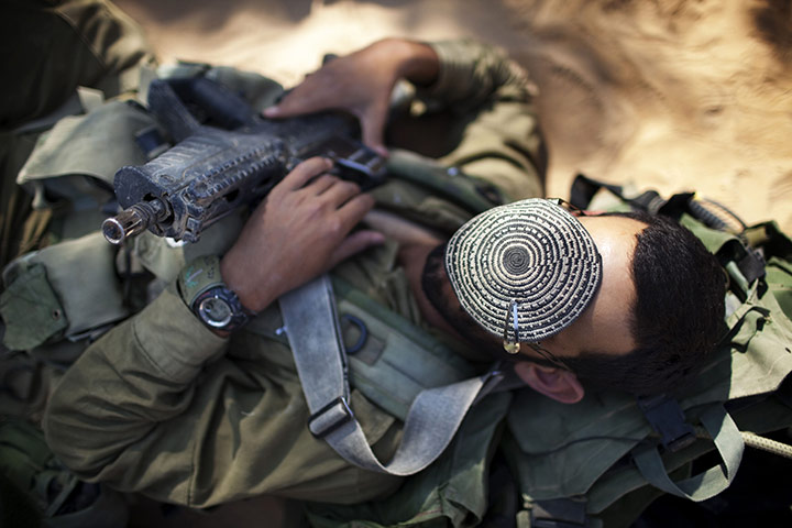 24 hours in pictures: Israeli infantry soldier rests during an open field combat exercise