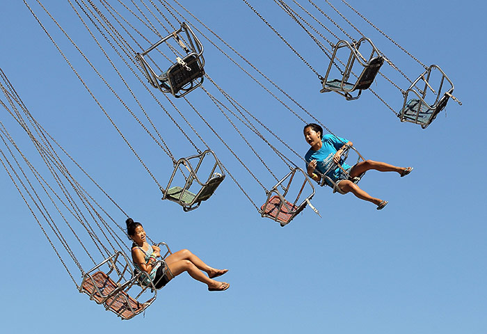 24 hours in pictures: People ride on a swing ride at the Alameda County Fair, California