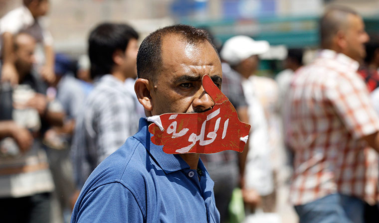 24 hours in pictures: Iraqi protester with a symbolic hand and the word 