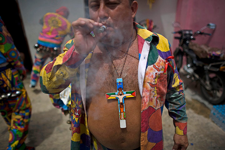 24 hours in pictures: A man smokes a cigar at the celebrations of Corpus Christi, Venezuela