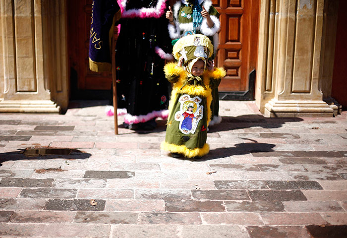 24 hours in pictures: Child dressed in the traditional outfit of a 