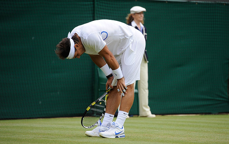 Wimbledon day 6: Rafael Nadal gets to his feet after slipping on the wet court