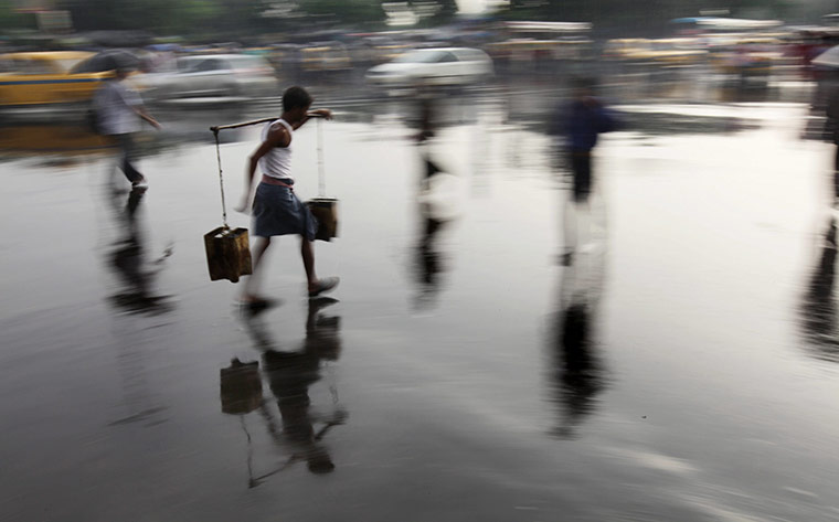 24 Hours: Kolkata, India: An Indian water vendor crosses a street 