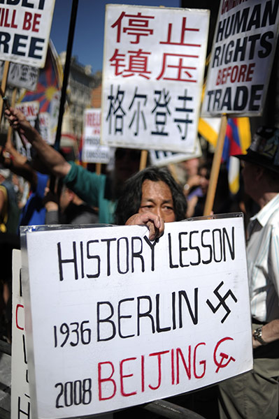 Wen Jiabao in UK: A man holds up a placard as he takes part in a protest