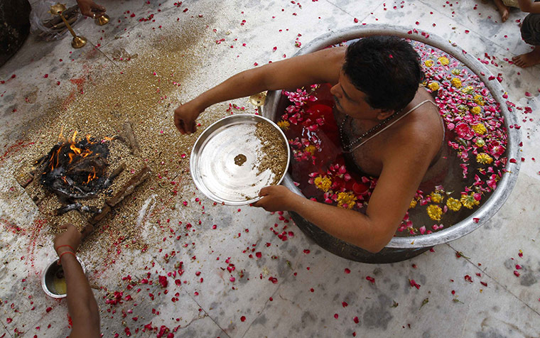 24 hours in pictures: a Hindu priest performs a prayer for rain in Ahmedabad